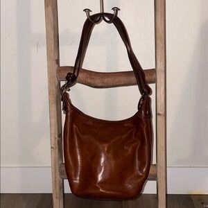 Brown Leather Coach Shoulder Bag with Buckle strap and plaid interior